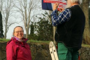Brigitta & Haiko hängen Wahlkampfplakat von Heiko Frost, Landtagswahl SH 2022, auf