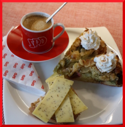 Tasse mit SPD Aufschrift und Teller mit Kuchen und Käsebrötchen